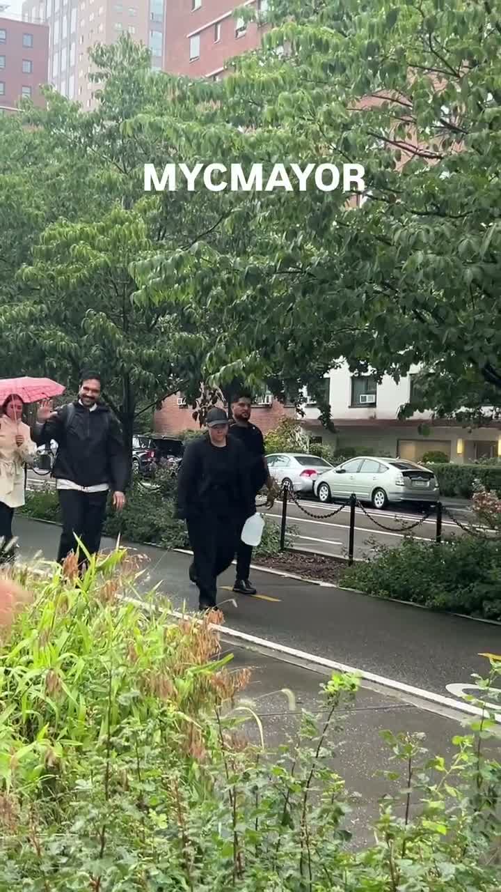 Mamdani waves to onlookers during the march