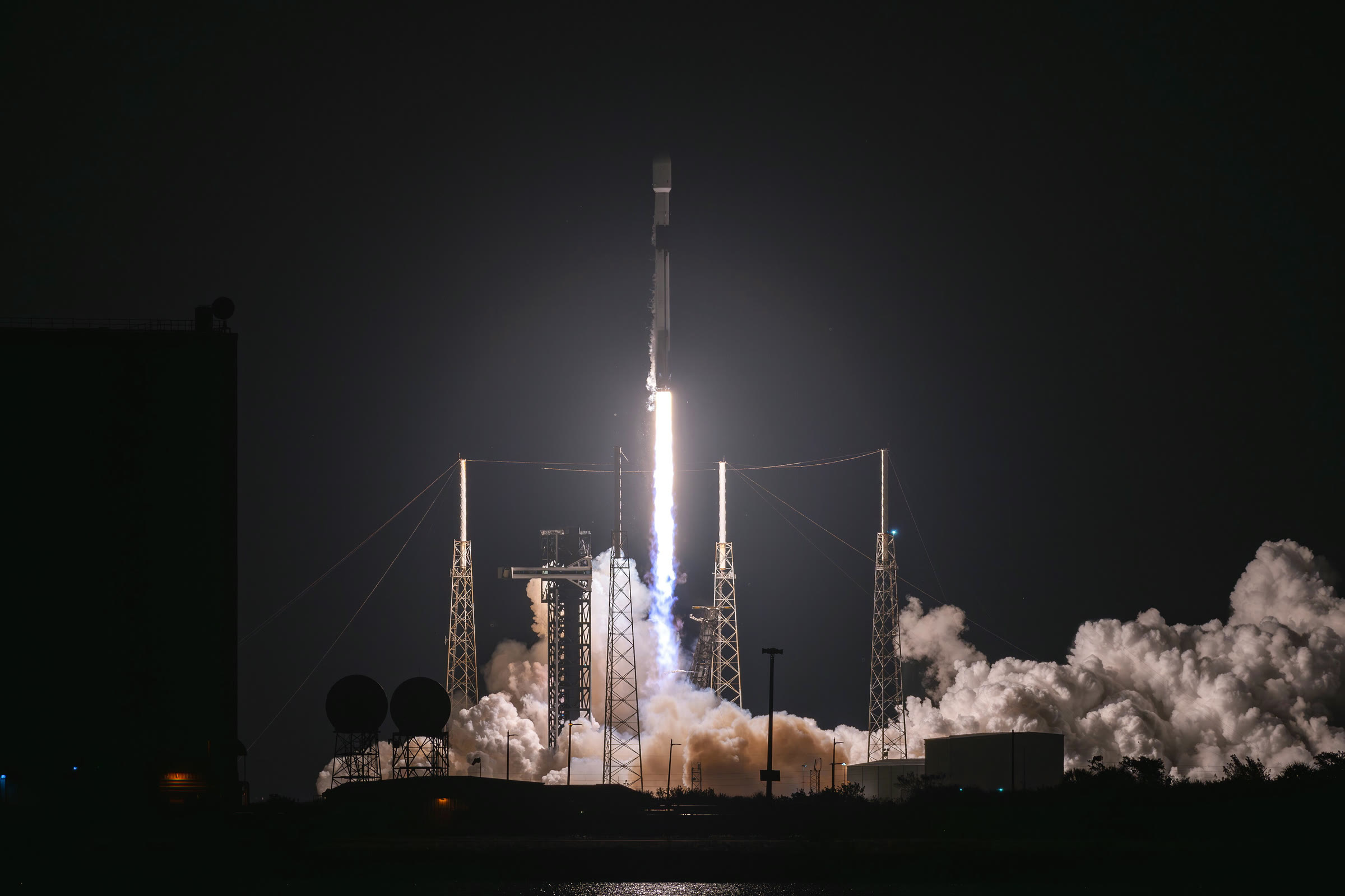 A Falcon 9 rocket launches a batch of Starlink satellites at night
