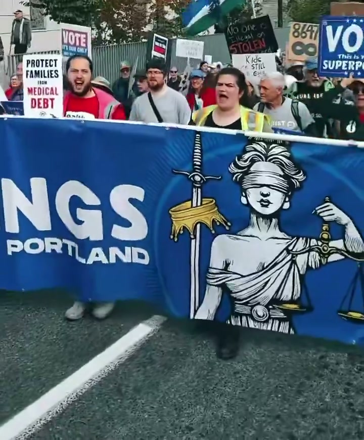 Marchers behind a “No Kings Portland” banner