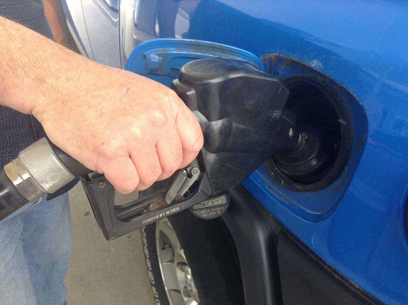 A driver filling a vehicle with gasoline at a fuel station in the U.S. (illustrative)