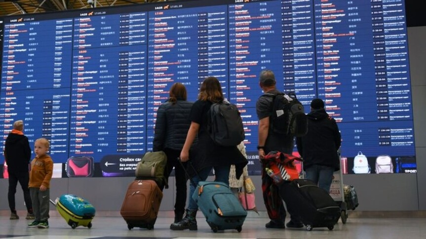Passengers in front of a departures board at Sheremetyevo Airport