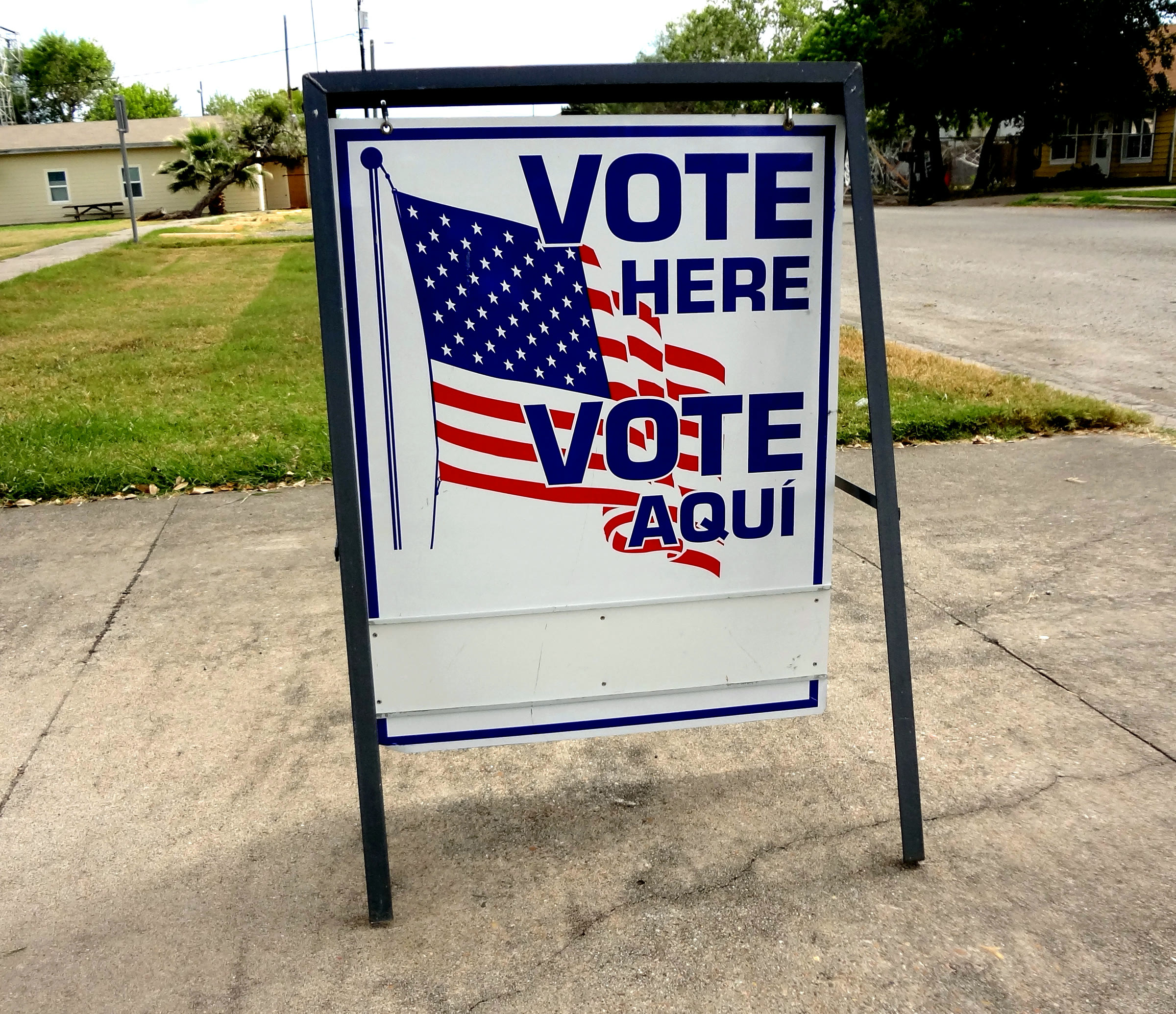 A bilingual "Vote Here" sign at a Texas polling place