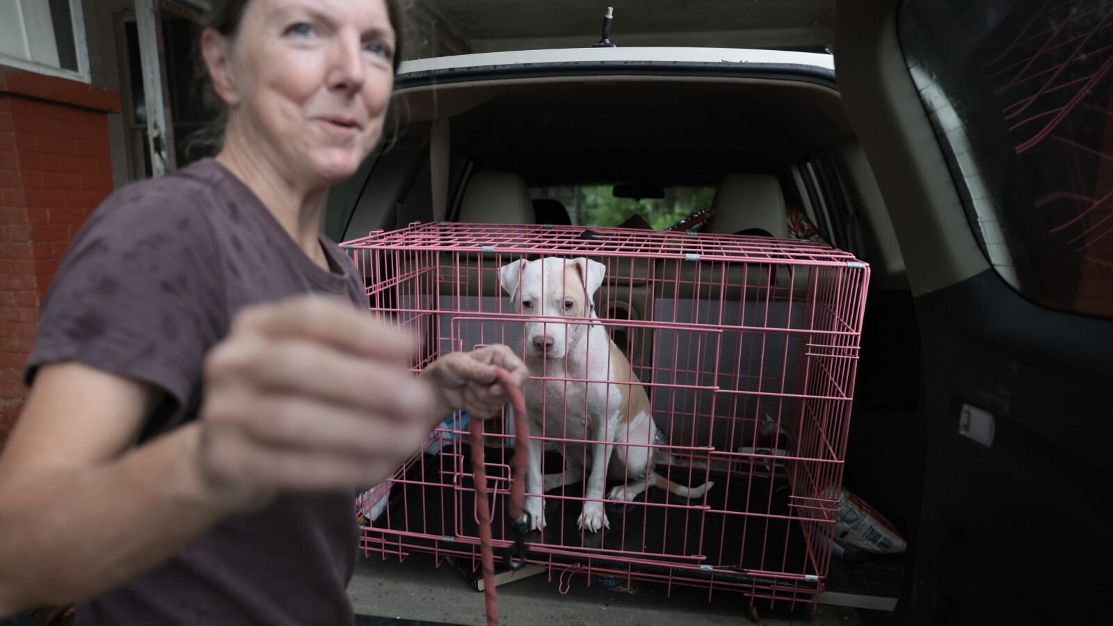 A woman evacuates her home with her dog in Pensacola ahead of the storm