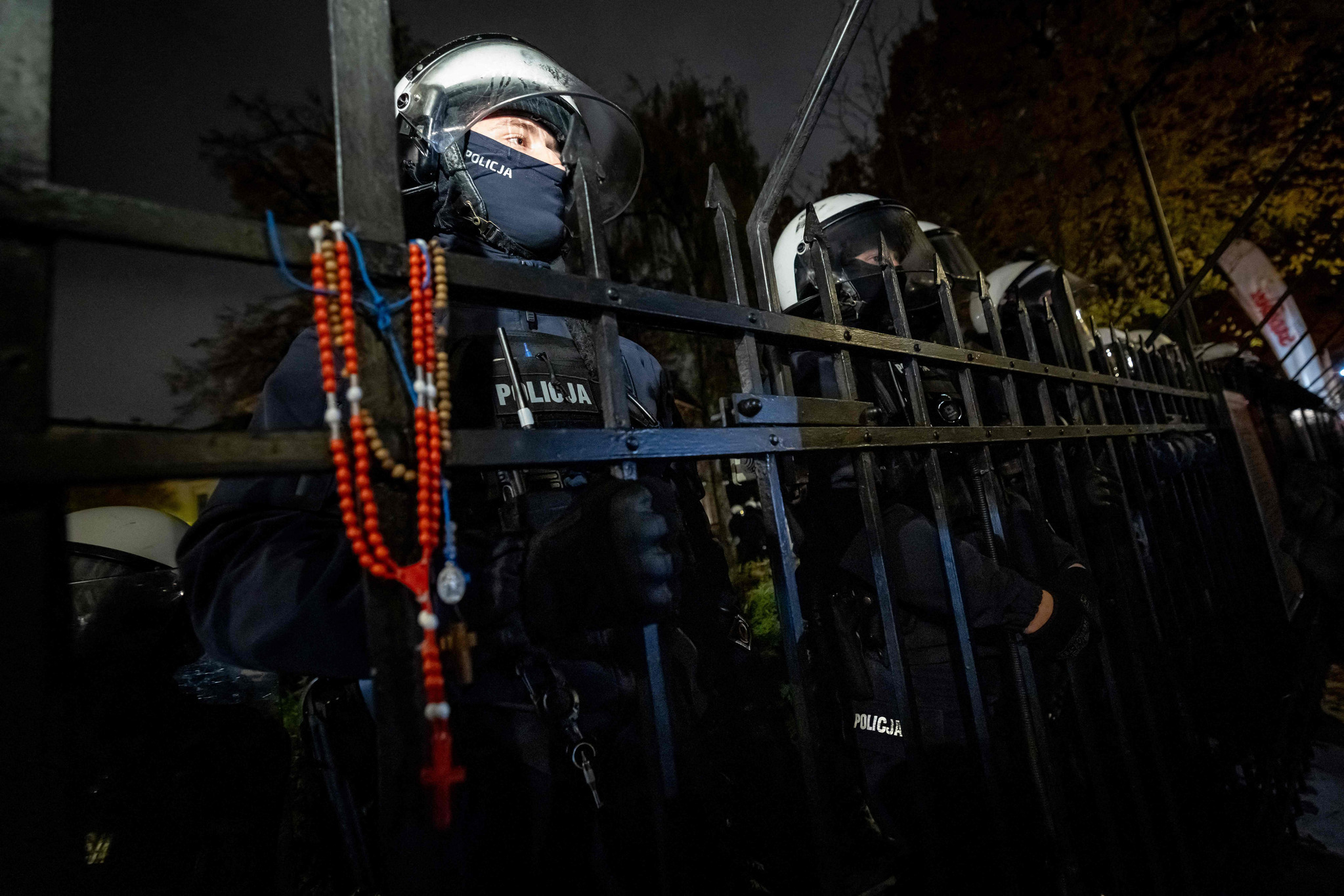 Varşova'da, çitine tespih asılmış mahkemenin arkasındaki polis memurları