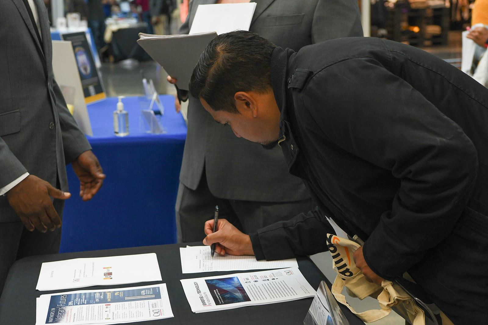 A job seeker fills out a form at a job fair (archive)