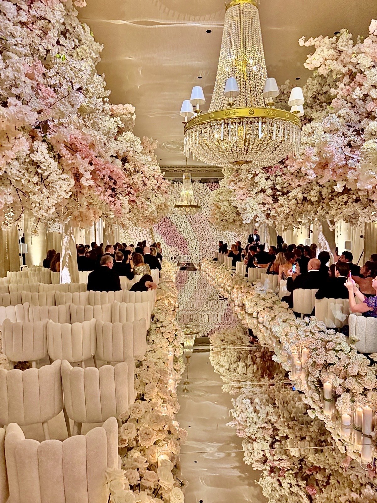The ceremony aisle lined with white and pink blossoms