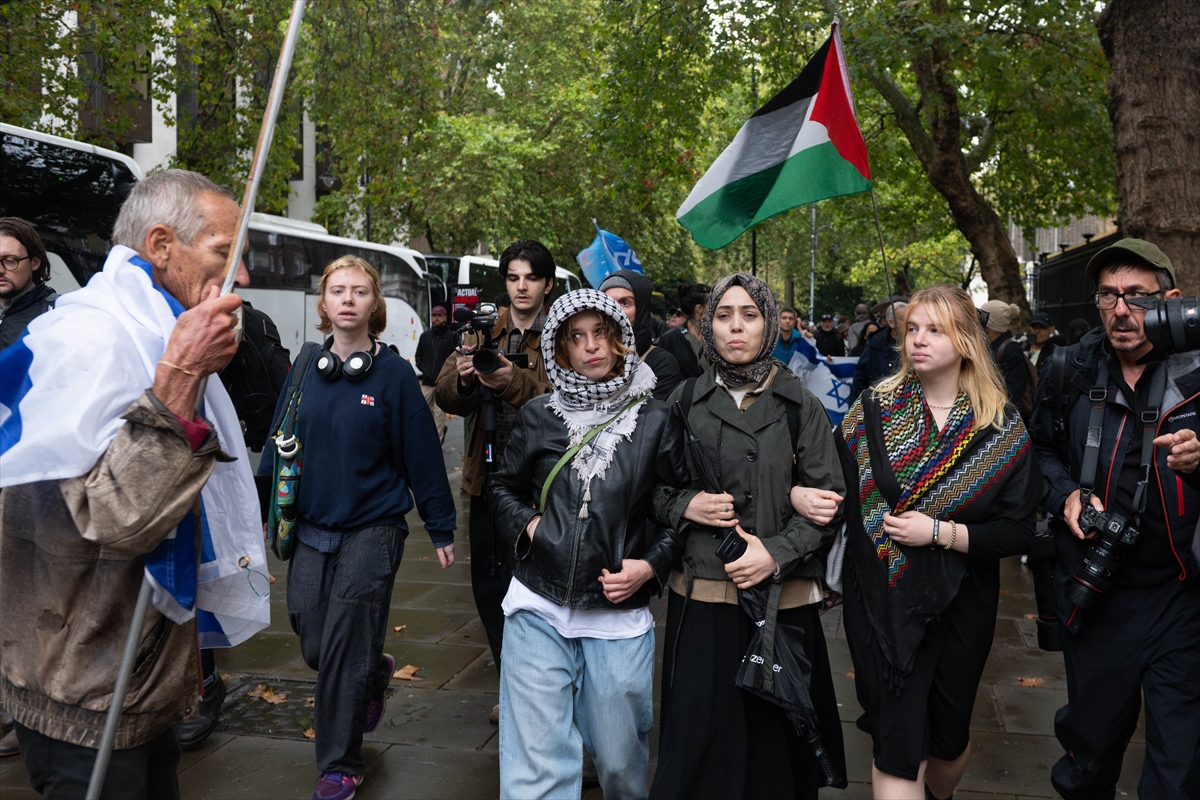 Demonstrators marching with a Palestinian flag