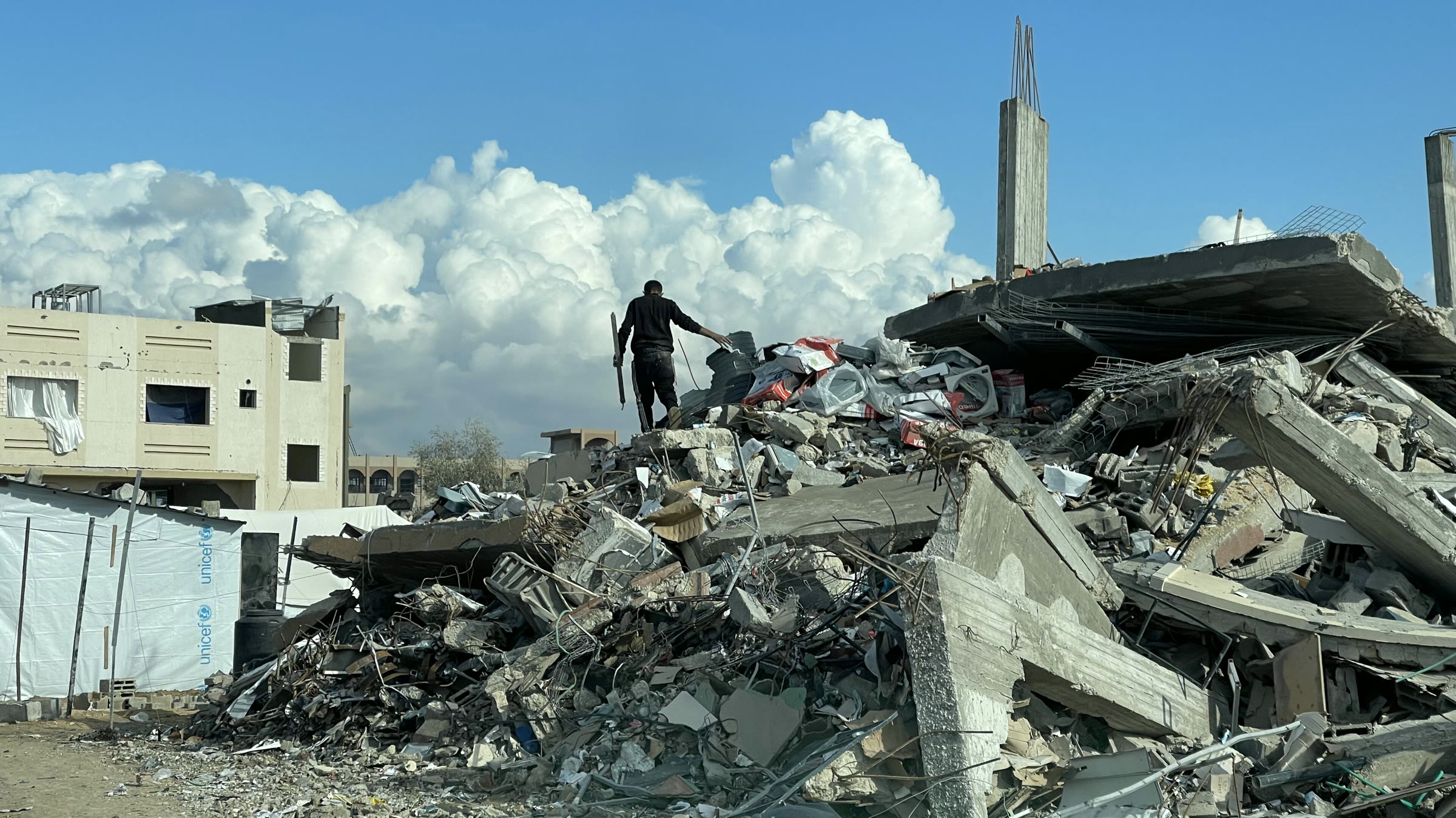 A man stands on the rubble of destroyed houses in Gaza