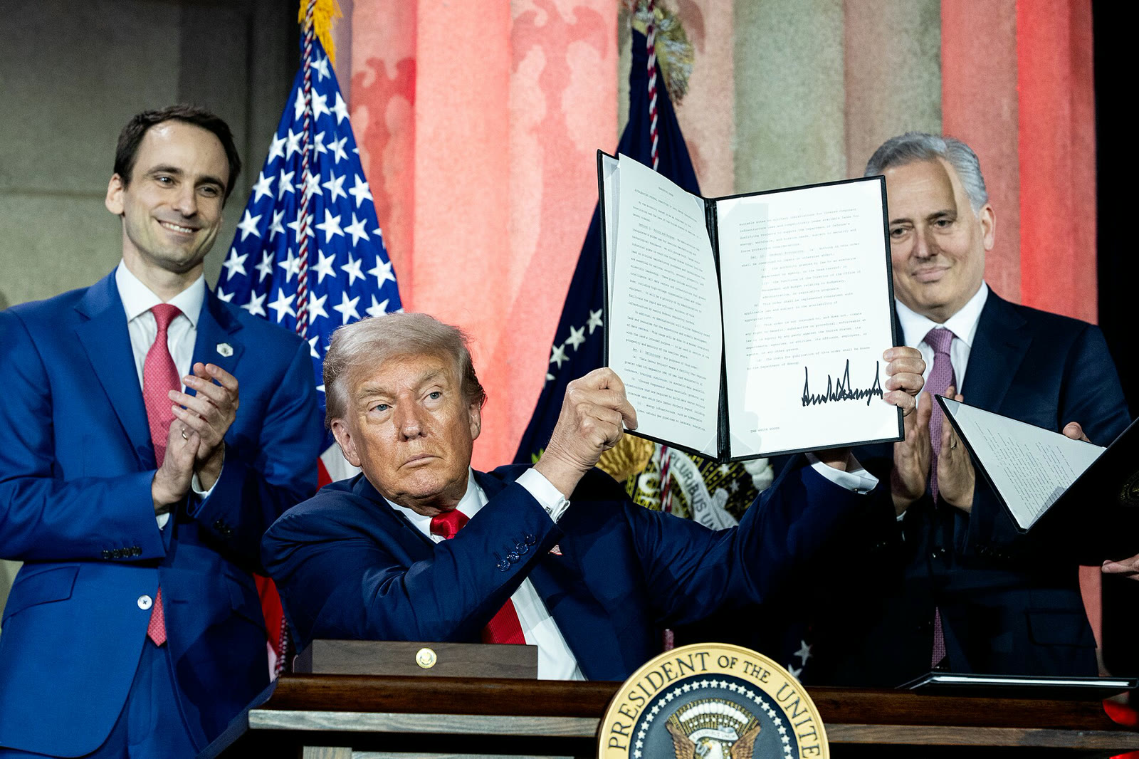Trump, Temmuz 2025'teki Beyaz Saray yapay zeka zirvesinde imzaladığı kararnameyi gösteriyor
