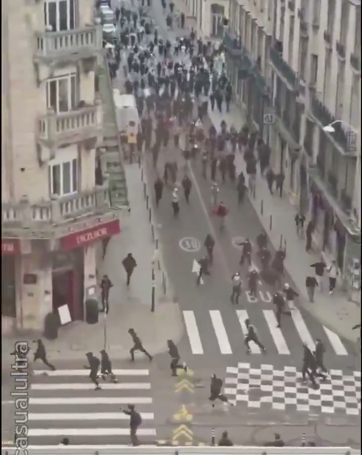 Protesters chase police down a street
